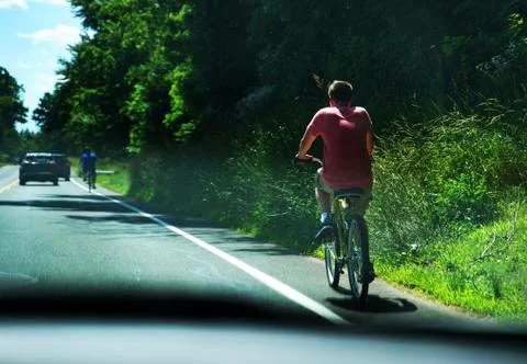 A driver`s view of young men on bicycles utilizing the roads bike lanes on a  Stock Photos