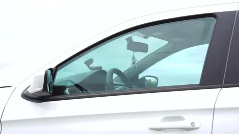 The driver's window closes in the car and then the car leaves Stockbeeldmateriaal 142525341