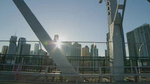 Driving across a bridge watching the sunset start to flare over the city Stock Footage 106364963