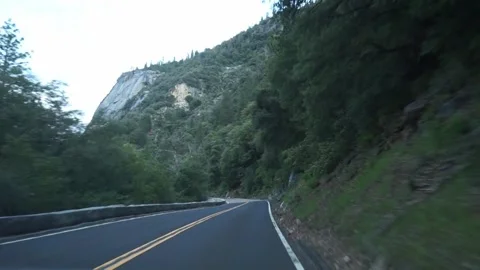 Driving along 35 mph road in Yosemite Valley Stock Footage 241961069