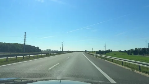 Driving along a clear highway under a bright blue sky on a sunny day Stock Footage 318297528