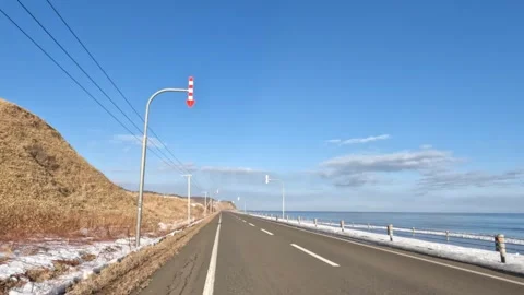 Driving along an empty road by the sea in winter Stock Footage 272900691