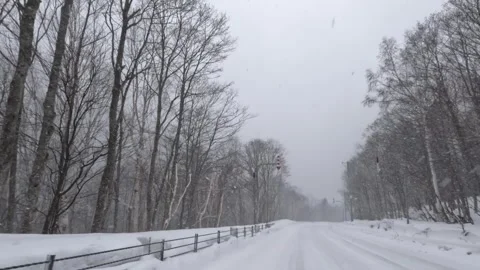 Driving along an empty winter road in heavy snowfall Stock Footage 272893086