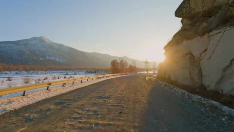 Driving along snowy mountain road at golden sunset POV shot Stock Footage 346636364