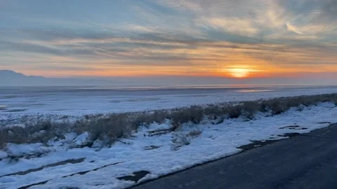 Driving away from snowy sunset with clouds Video stock 329449172