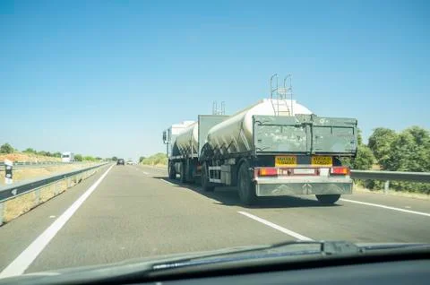Driving behind B-double trailer loading tanks on divided highway road Stock Photos
