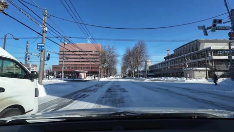 Driving behind white van on snowy urban road in Asahikawa Japan Stock Footage 333314075