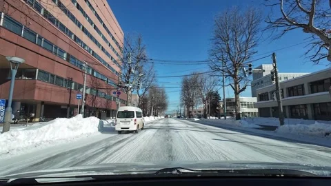 Driving behind white van on snowy tree lined street in Asahikawa Japan 스톡 동영상 333314082