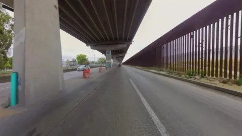 Driving beneath the elevated highway under construction beside the U.S.-Mexico. Stock Footage 336807934