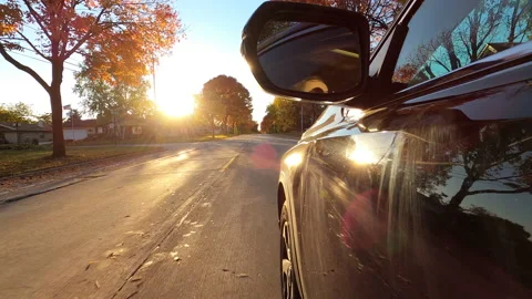 Driving a black SUV car down a suburban street in fall season Stock Footage 141085493