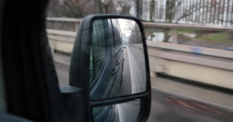Driving up a bridge in germany during winter weather in a dark van, side mirror Stock Footage 230490302