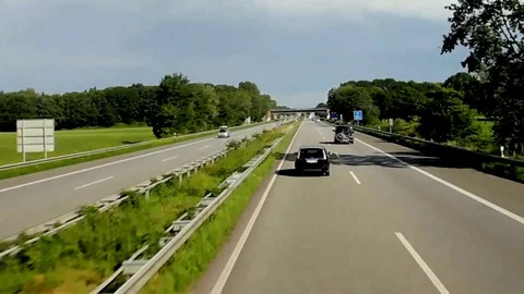 Driving Bus on the Highway With Cloads by a Frontier Mark Between Germany and Stock Footage 72220286