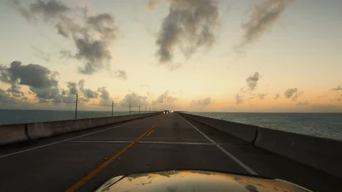 Driving a car along Florida Keys highway bridges during sunset. POV Stock Footage