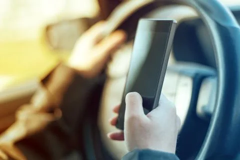 Driving car and using mobile phone to send text message 스톡 사진