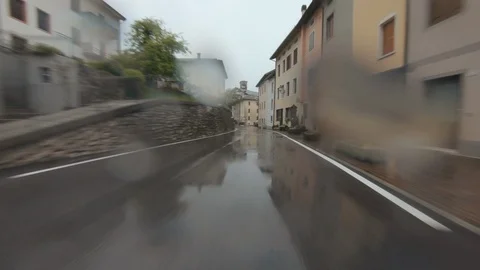 Driving a Car in Heavy Rain Through a Small Italian Village in the Dolomites Stock Footage 112190575