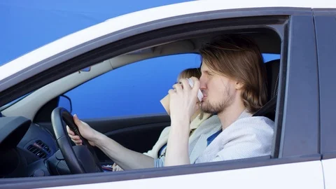 Driving a car man is drinking coffee in paper glass and chatting with blonde Stock-Footage 124720852
