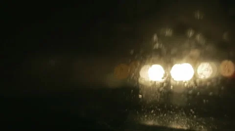 Driving a car at night. Raindrops on the windshield. Many lights out of focus. Vídeo Stock 68025430