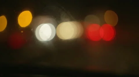 Driving a car at night. Raindrops on the windshield. Different color lights. Vídeo Stock 68025930