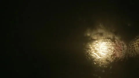 Driving a car at night. Raindrops on the windshield. Headlights out of focus. Stock Footage 68026898
