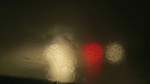 Driving a car at night. Raindrops on the windshield. Taillights out of focus. Stock Footage 68028842