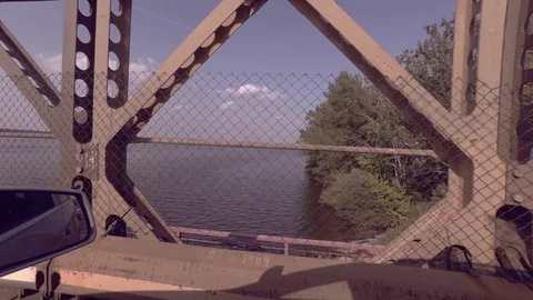 Driving with car over bridge, driver view to the side, view on a lake 스톡 동영상 111948312