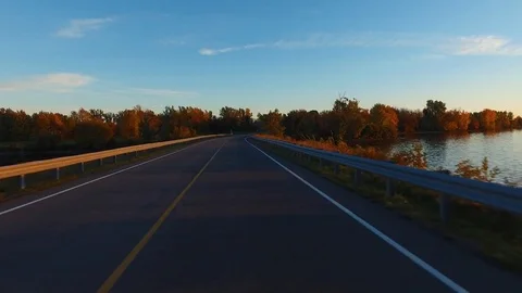 Driving a Car in Point of View Perspective on a Road into Sunset Video stock 84868336