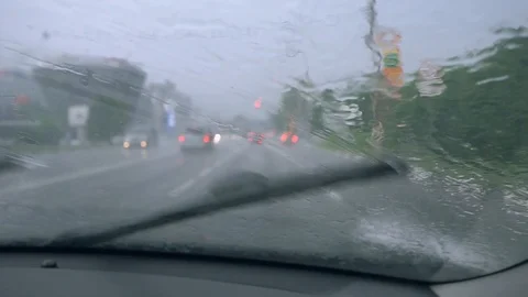 Driving car in the rain on wet road. Rainy weather through the car window. Stock Footage