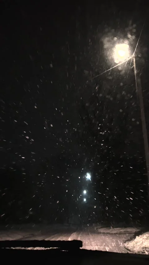 Driving a car in snowfall. Snowfall through the windshield of a car. Snow falls Stock Footage 261222532