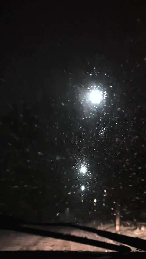 Driving a car in snowfall. Snowfall through the windshield of a car. Snow falls Stock Footage 276507220