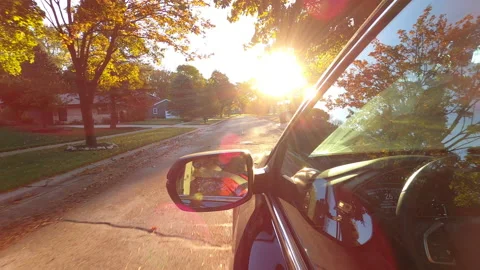 Driving a car at sunrise, sunset in American neighborhood. Stock Footage 140372553