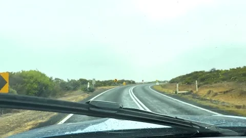 Driving car on a winding road with rain on windshield, great ocean road, vi.. Stock Footage 333767724