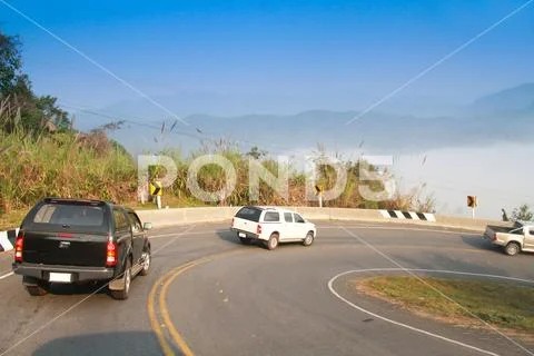 Driving on curve road in the mountain with the sea mist Stock Photos
