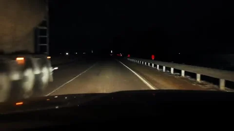 Driving on a dark road at night with headlights illuminating the path ahead Stock-Footage 323954705