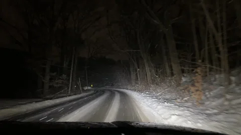 Driving on a dark snow covered rural road during a snow storm Stock Footage 322650997