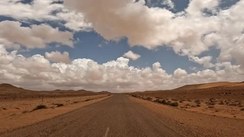Driving on desert road with clouds in blue skyriver view Video stock 279849361