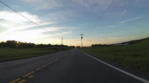 Driving Down a Country Road at Sunset Stock Footage 58784352