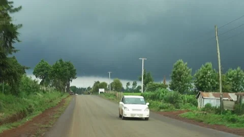 Driving down a dirt road in Kenya into a dark storm front Stock Footage 194502958