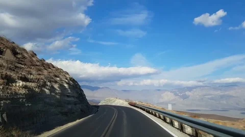 Driving down from a mountain on asphalt road in Death valley, California, in  Stock Footage 69964784