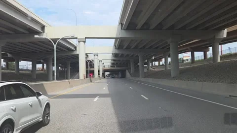 Driving down a three lane highway with an elevated highway above Stock Footage 325004575