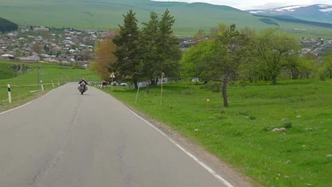 Driving down a winding mountain road overlooking a valley town Vidéo 339501976