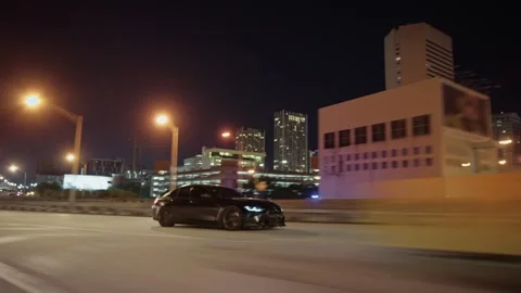 Driving on an elevated highway through a blurred city skyline at night Vídeos de archivo 341956731