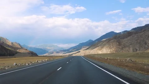 Driving on empty asphalt road passing through mountain hilly valley prairie Stock Footage 290023344
