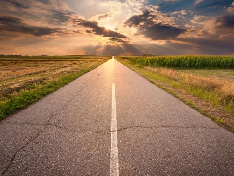 Driving on an empty asphalt road at sunset Stock Photos