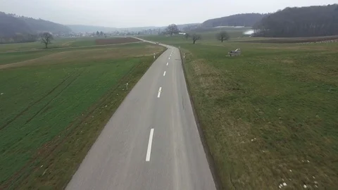 Driving on an empty asphalt road through the wheat fields with snow and fog. Stock Footage 120959364