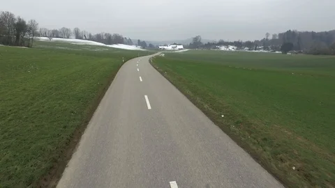 Driving on an empty asphalt road through the wheat fields with snow and fog. Stock Footage 120959399