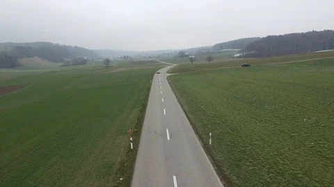Driving on an empty asphalt road through the wheat fields with snow and fog. Stock Footage 120959587