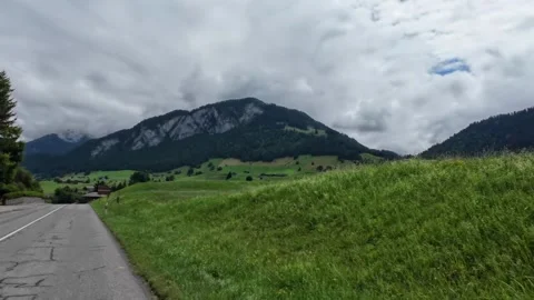 Driving Empty Country Road with Grass Field and Mountains Stock Footage 341365172