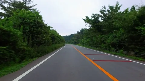 Driving a empty country road to Volcano Aso mountain Stock Footage 77062509