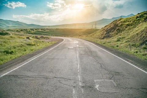 Driving on an empty open road in sunset Stock Photos