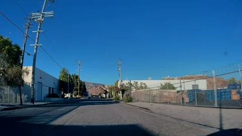 Driving on an empty road along an industrial street, Los Angeles, golden hour Stock Footage 343475426